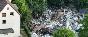 Feuerwehrleute untersuchen die Trümmer eines eingestürzten Hauses.