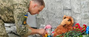 Ein ukrainischer Soldat zündet eine Kerze am Ort des russischen Beschusses in Winnyzia ab.