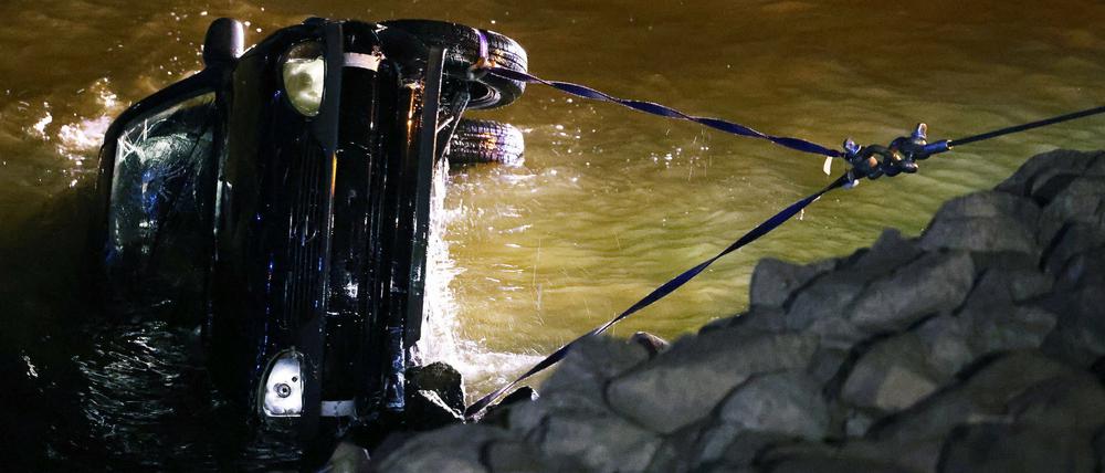 Rettungskräfte bergen das versunkene Auto aus dem Rhein.