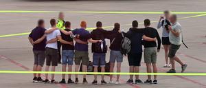 Die acht Männer, die auf Mallorca wegen Brandstiftung in Untersuchungshaft gesessen haben, stehen nach ihrer Ankunft in Deutschland auf dem Flugfeld auf dem Flughafen Münster-Osnabrück zusammen. 