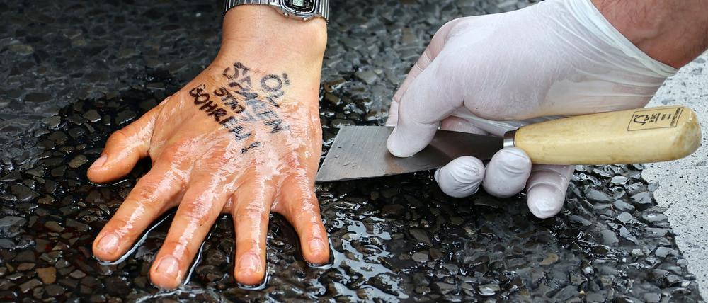 Ein Berliner klebt sich aus Protest gegen Ölverbrauch auf der Fahrbahn fest.