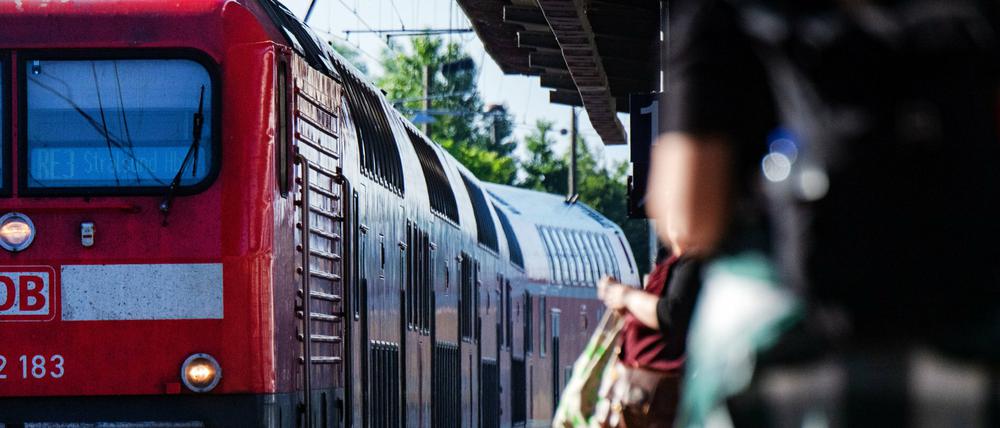 Fahrgäste warten an einem Bahnhof in Stralsund auf eine Regionalbahn. 