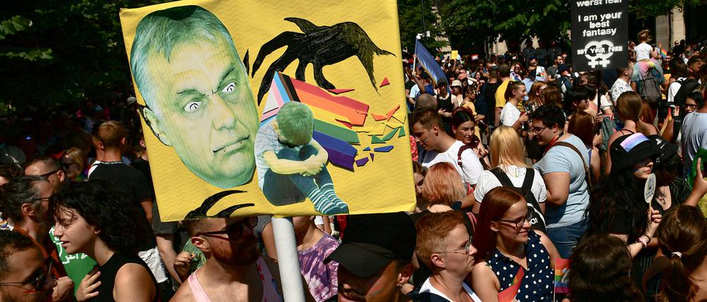 Menschen halten bei einer Gay Pride Parade in Budapest ein Plakat mit dem Gesicht des ungarischen Ministerpräsidenten Orban.