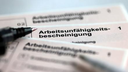 Stifte liegen auf den Arbeitsunfähigkeitsbescheinigungen für Arbeitnehmer im Falle einer Krankschreibung. 