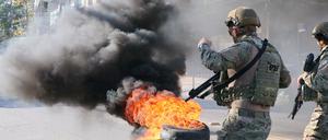 Reifen brennen in der Favela Complexo do Alemao während Beamte im Einsatz sind.