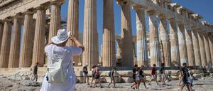 Eine Touristin macht Fotos vom Parthenon auf der Athener Akropolis. 