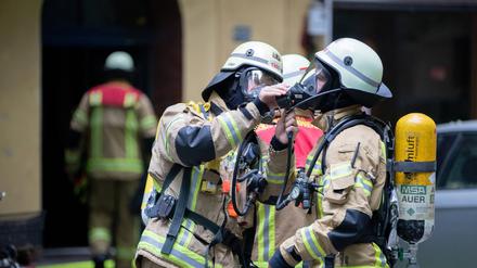 19.06.2020, Berlin: Feuerwehrmänner befestigen bei einem Feuerwehreinsatz in der Kirchstraße in Berlin-Moabit ihre Atemmasken. In einem Wohnhaus hat es eine Explosion gegeben. Foto: Christoph Soeder/dpa +++ dpa-Bildfunk +++