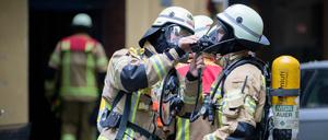 Feuerwehrleute befestigen ihre Atemmasken. 