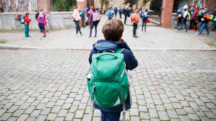 Schulkinder stehen vor einer Berliner Schule. 