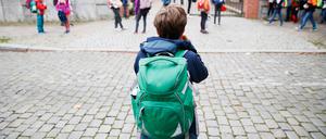 Schulkinder stehen vor einer Berliner Schule. 