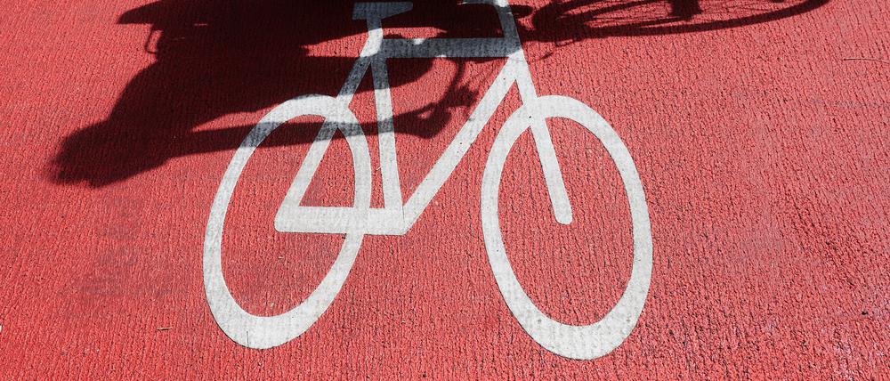 Ein Radfahrer wirft einen Schatten auf das Fahrradzeichen.