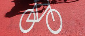 Ein Radfahrer wirft einen Schatten auf das Fahrradzeichen.
