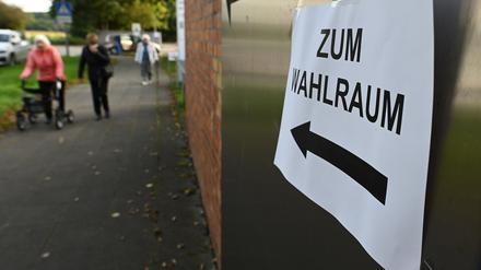 Ein Zettel mit der Aufschrift "Zum Wahlraum" hängt an einem eingerichteten Wahllokal. +++ dpa-Bildfunk +++