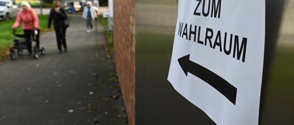Ein Zettel mit der Aufschrift "Zum Wahlraum" hängt an einem eingerichteten Wahllokal. +++ dpa-Bildfunk +++