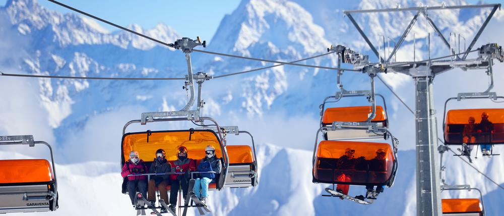 Skifahrer sitzen im Skigebiet Ischgl in einem Sessellift.
