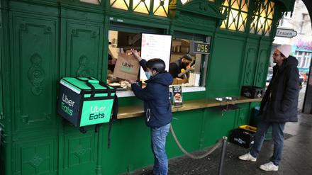 Ein Fahrer von Uber Eats am Burgermeister-Imbiss am Schlesischen Tor eine Lieferung ab.