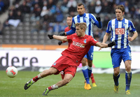 Sören Brandy behauptet im roten Trikot des MSV Duisburg den Ball gegen zwei Hertha-Spieler.