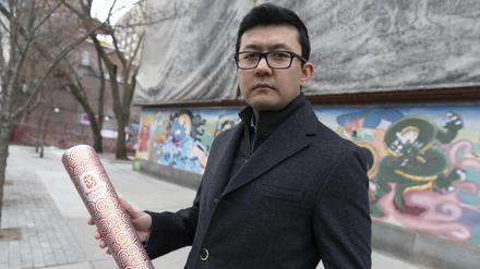 Kamaltürk Yalqun im Januar 2022 in Boston mit der olympischen Fackel, die er 2008 als 17-Jähriger bei den Sommerspielen in Peking trug.