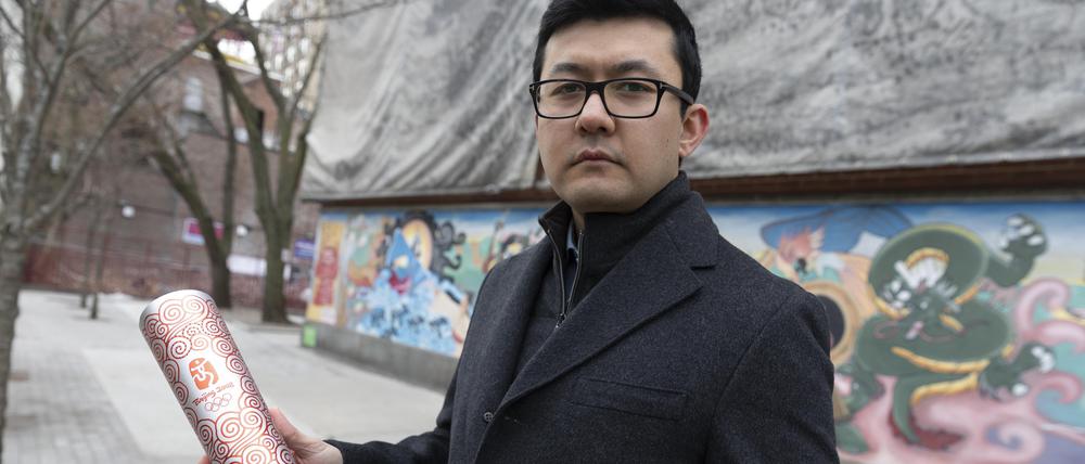 Kamaltürk Yalqun im Januar 2022 in Boston mit der olympischen Fackel, die er 2008 als 17-Jähriger bei den Sommerspielen in Peking trug.