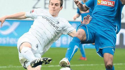 Mitreißendes Duell. Hoffenheims Marvin Compper (r.) und Johannes Flum vom SC Freiburg kämpfen um den Ball.