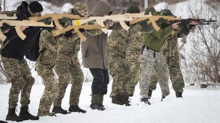 Anwohner trainieren in der Nähe von Kiew mit Holzattrappen als Gewehr.