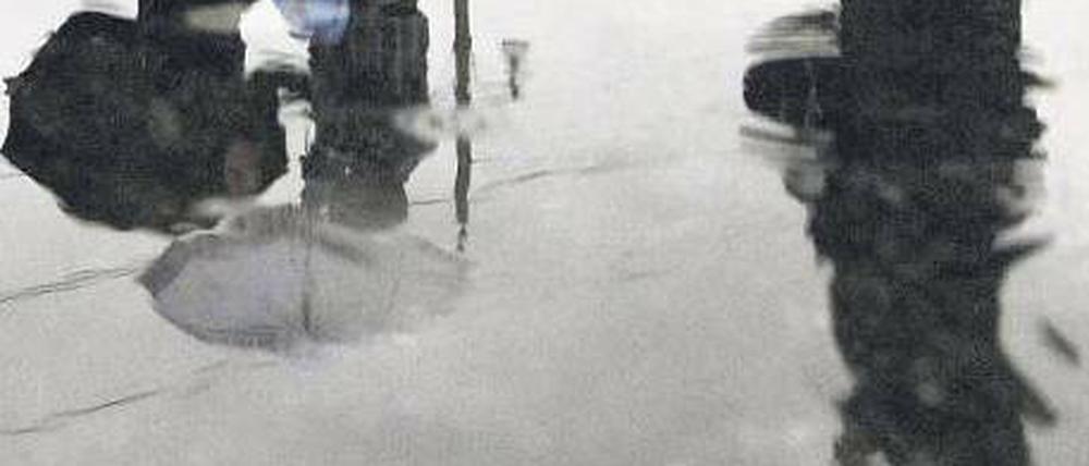 Geduld im Dauerregen. Viele Touristen verbringen das lange Brückentagswochenende in Berlin und ließen sich – wie hier vor dem Martin-Gropius-Bau – die Laune trotz des miesen Wetters nicht verderben. Drinnen wurden sie mit Wärme und Kulturgenuss in der Frida-Kahlo-Ausstellung belohnt. 