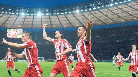 Zum Abheben. Die Bayern Ivica Olic, Daniel van Buyten und Martin Demichelis (von links) toben sich im Olympiastadion aus. Foto: dpa