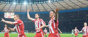 Zum Abheben. Die Bayern Ivica Olic, Daniel van Buyten und Martin Demichelis (von links) toben sich im Olympiastadion aus. Foto: dpa