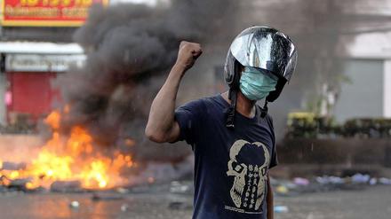 Bürgerkriegsähnliche Zustände: Ein oppositioneller Demonstrant posiert vor brennenden Barrikaden in Bangkok.