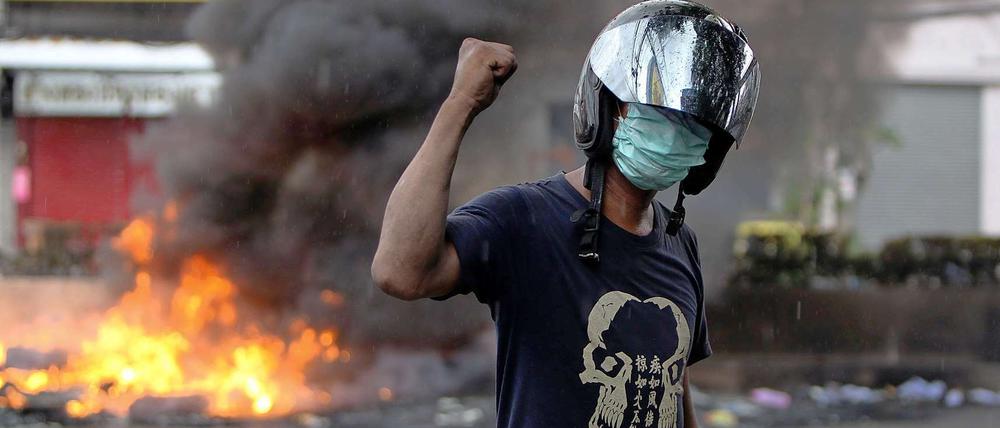 Bürgerkriegsähnliche Zustände: Ein oppositioneller Demonstrant posiert vor brennenden Barrikaden in Bangkok.