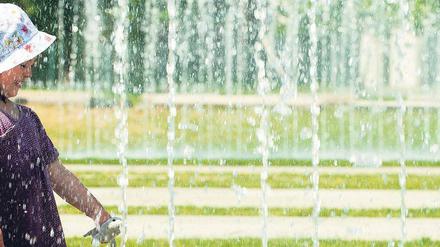 Konkurrenz fürs Tor. Die Wasserfontänen vor dem Bundeskanzleramt ziehen zur Sommerzeit mehr und mehr Fans an: planschende Kinder, tobende Jugendliche, küssende Paare – und die Fotografen. Bei Touristen dürften die Fontänen schon zu den beliebtesten Motiven aus dem sonnigen Berlin gehören. Foto: Bilan/dapd
