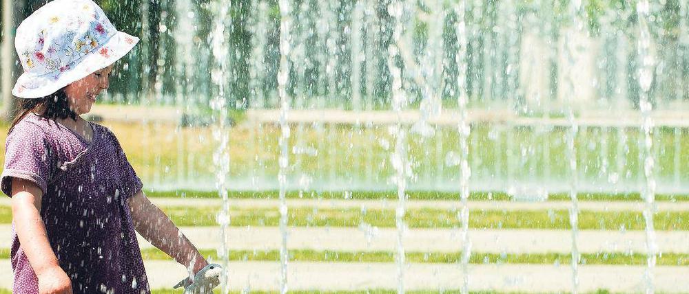 Konkurrenz fürs Tor. Die Wasserfontänen vor dem Bundeskanzleramt ziehen zur Sommerzeit mehr und mehr Fans an: planschende Kinder, tobende Jugendliche, küssende Paare – und die Fotografen. Bei Touristen dürften die Fontänen schon zu den beliebtesten Motiven aus dem sonnigen Berlin gehören. Foto: Bilan/dapd