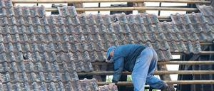 Kein Dach mehr über dem Kopf. Ein Mann versuchte am gestrigen Montag in Mühlberg an der Elbe die losen Ziegel zu entfernen. Eine starke Windhose hatte am Pfingstmontag das südbrandenburgische Städtchen verwüstet und bei mehr als einhundert Häusern die Ziegeldächer abgedeckt. Wie durch ein Wunder wurde niemand verletzt. Foto: ddp