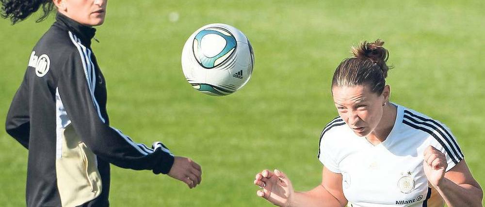 Kopfsache. Inka Grings (rechts, beobachtet von Fatmire Bajramaj) kämpft mit ihren Mannschaftskolleginnen gegen das Klischee des einfachen Titels. Foto: dpa