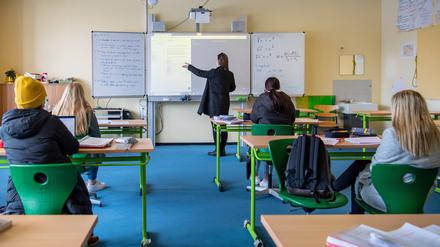  Eine Lehrerin und Schüler im Unterricht.