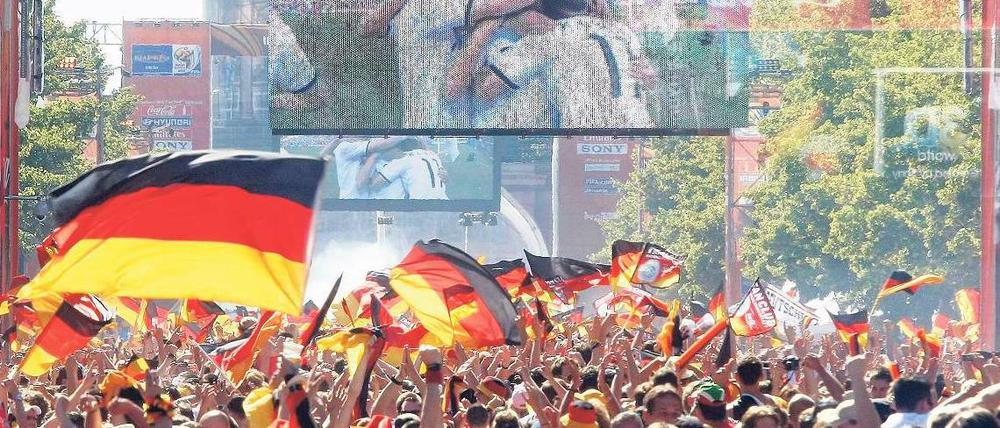 In der Ferne so nah. Auf der Fanmeile im Tiergarten wird die Nationalmannschaft gefeiert, hier erwartet man, die Elf auch leibhaftig empfangen zu können – nicht so schnell wie möglich, aber möglichst gleich nach dem Finale und mit dem Weltmeistertitel. Foto: Davids/Darmer