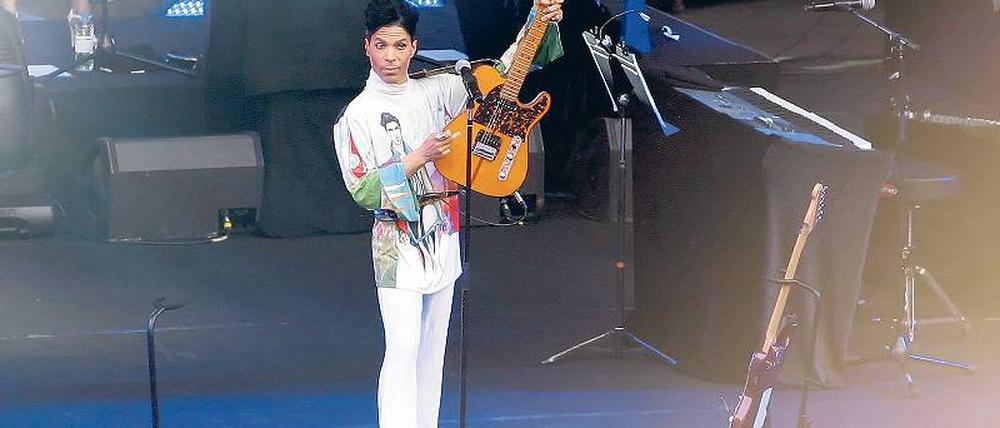 Triumphator. Prince präsentiert sein Herrschaftsinstrument. Das Seidenhemd zeigt das Plakatmotiv zur Tournee. Foto: Eventpress