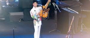 Triumphator. Prince präsentiert sein Herrschaftsinstrument. Das Seidenhemd zeigt das Plakatmotiv zur Tournee. Foto: Eventpress