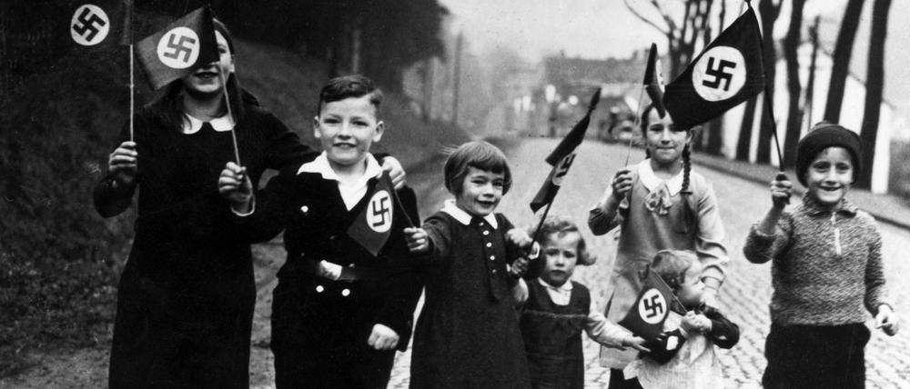 Propagandafoto für die Presse: Kinder mit Hakenkreuzfahnen.