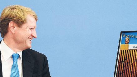 328 Mal hat er dort gesessen – auf dem Podium vor der Bundespressekonferenz. Als Abschiedsgeschenk bekam Ulrich Wilhelm unter anderem dieses Bild. Foto: Hannibal/dpa