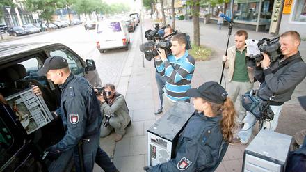 Polizisten tragen in Hamburg Computer aus dem Gebäude der Moschee.