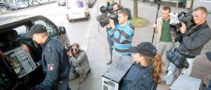 Polizisten tragen in Hamburg Computer aus dem Gebäude der Moschee.