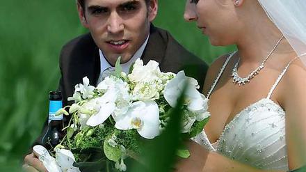 Fußball-Nationalspieler Philipp Lahm und seine Frau Claudia nach der kirchlichen Trauung in Kleinhelfendorf (Oberbayern).