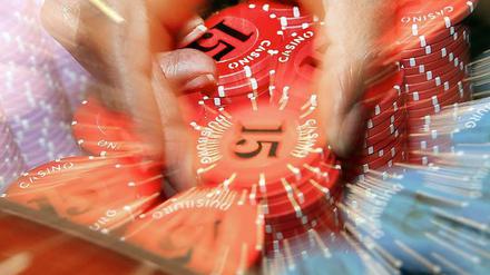 Eine Hand greift nach Jetons. Der Betrieb von Automatencasinos boomt in Berlin.