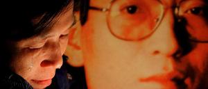 Eine Aktivistin neben einem Foto von Liu Xiaobo.