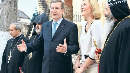 Vor der Kirche in Taurus. Bundespräsident Christian Wulff und Ehefrau Bettina unterhalten sich vor dem ökumenischen Gottesdienst. Offizielle türkische Vertreter kamen nur zu Begrüßung, gingen aber nicht in die Kirche. Foto: Steffen Kugler/dpa