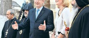 Vor der Kirche in Taurus. Bundespräsident Christian Wulff und Ehefrau Bettina unterhalten sich vor dem ökumenischen Gottesdienst. Offizielle türkische Vertreter kamen nur zu Begrüßung, gingen aber nicht in die Kirche. Foto: Steffen Kugler/dpa