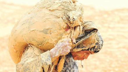 Der Reichtum dieser Welt. Wertvolle Erde trägt dieser chinesische Arbeiter in der Provinz Jiangxi auf seiner Schulter. 