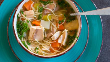 fresh cooked chicken noodle soup in a large bowl from above on dark table background. Ready to eat