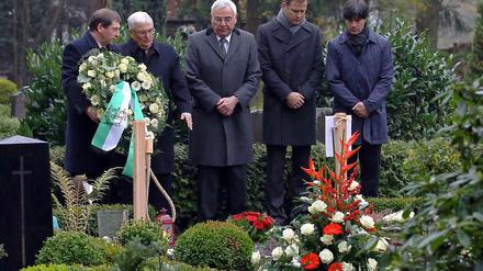 DFB-Präsident Theo Zwanziger (2.v.l.) beobachtet am 10. November 2010 zusammen mit Oliver Bierhoff (2. v. r.) und Joachim Löw (r.) die Kranzniederlegung am Grab von Robert Enke.